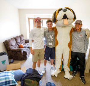 Three males with Basil in a dorm room in 2019