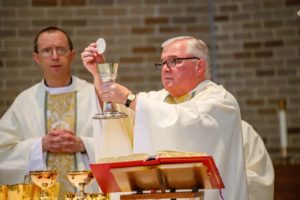 Rev. David T. Tyson, C.S.C., during communion at Mass