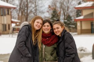 Three female students enjoying some winter fun outdoors