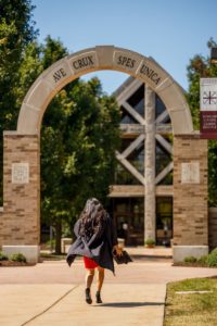 Female graduate walking under the arch