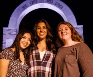 Three female students together at the arch from welcome weekend 2020.