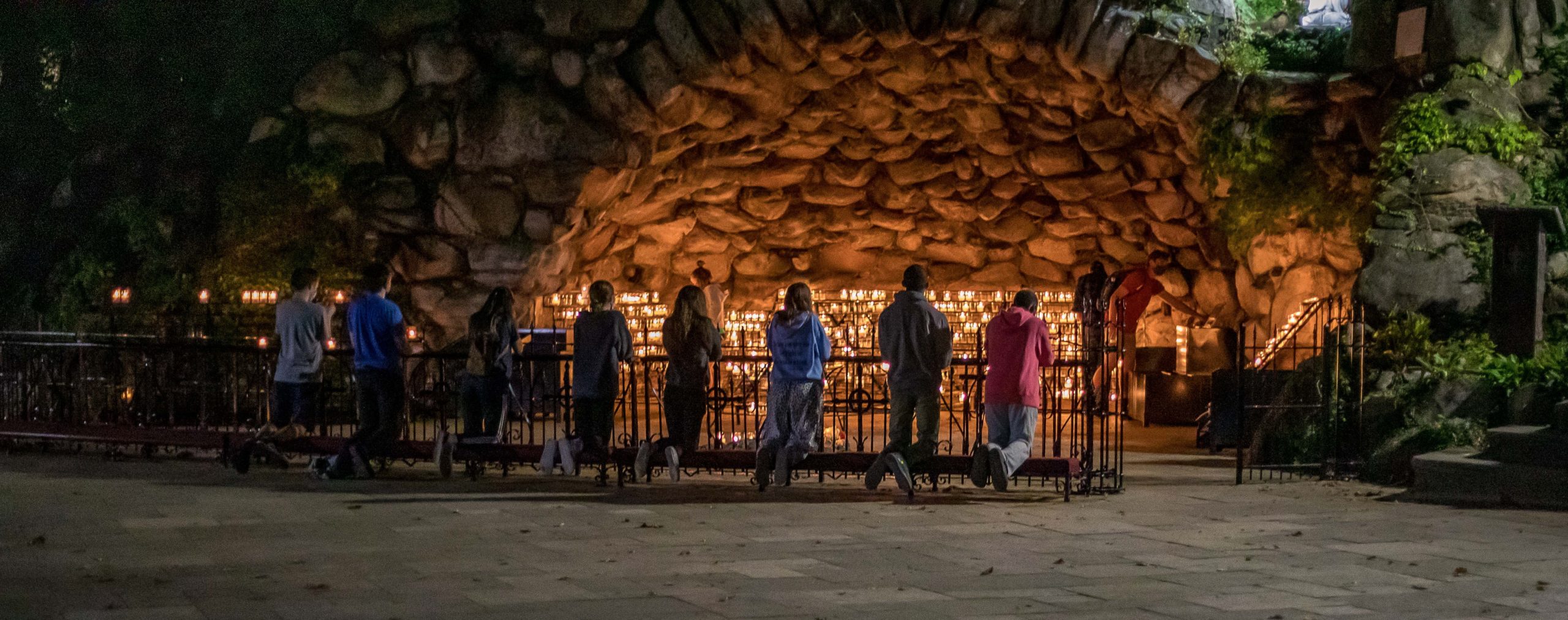 Students praying at the Grotto at the University of Notre Dame