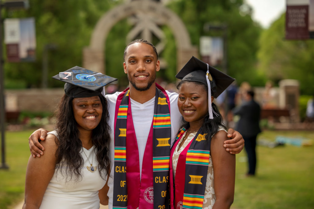 Three class of 2021 students together at graduation.